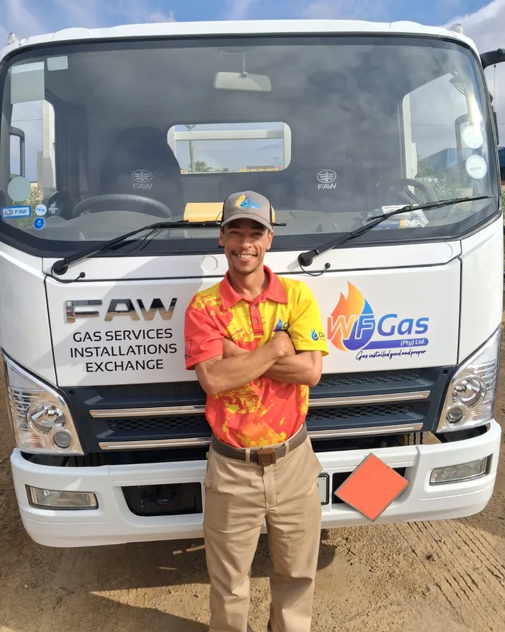 A WF Gas team member with arms crossed in front of the WF Gas truck